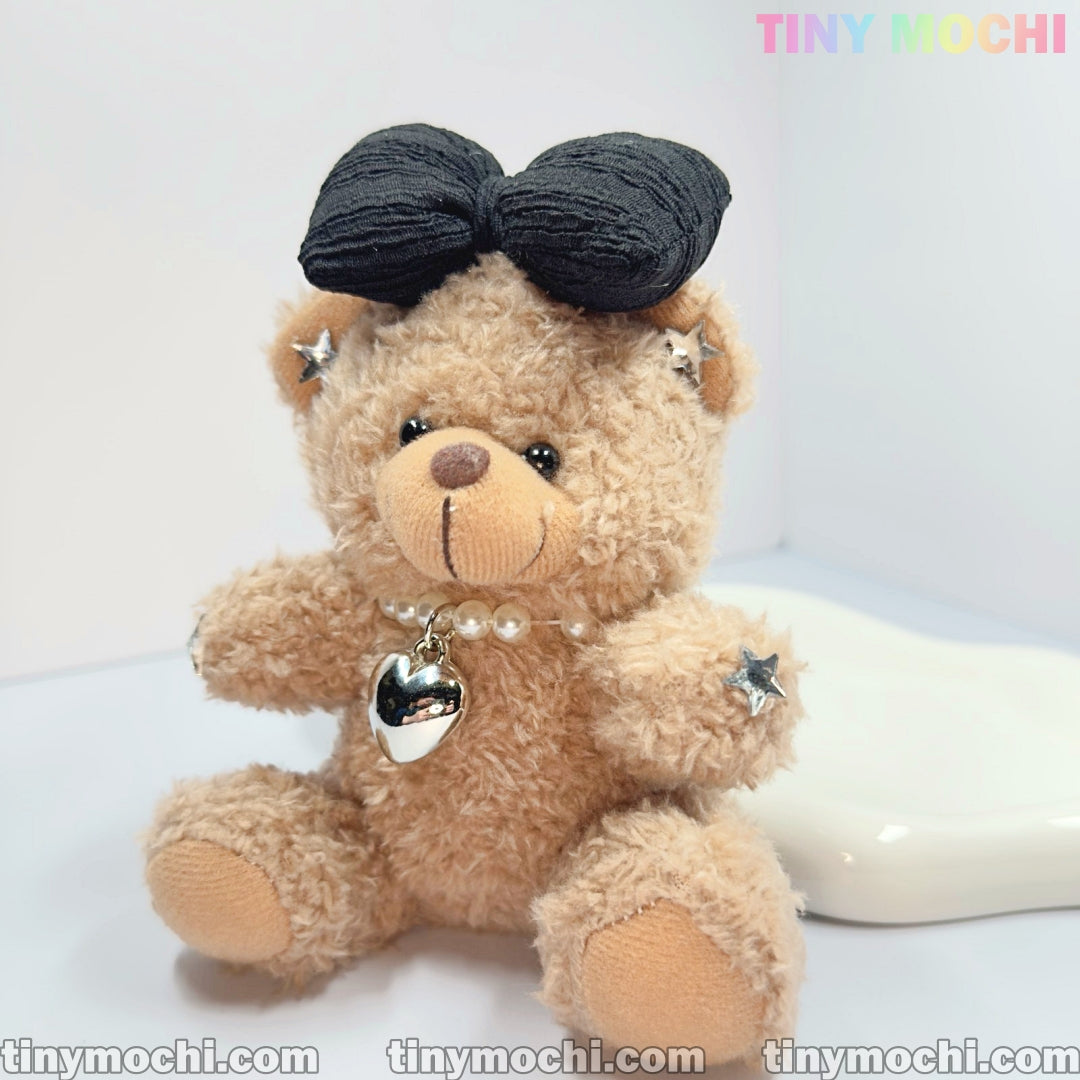 The Tiny Mochi Plush Teddy Bear Keychain with Bow and Pearl Necklace is a cute, stylish bag charm for women. With star accents and a heart pendant, it’s the perfect accessory or gift for girls who love adorable details!.