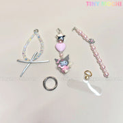 Five pastel accessories from the Tiny Mochi Kawaii Angel Charm Keychain Kit are displayed on a light background, featuring pearls, ribbon, star charms, and beads. The Tiny Mochi logo is shown in the top right corner.