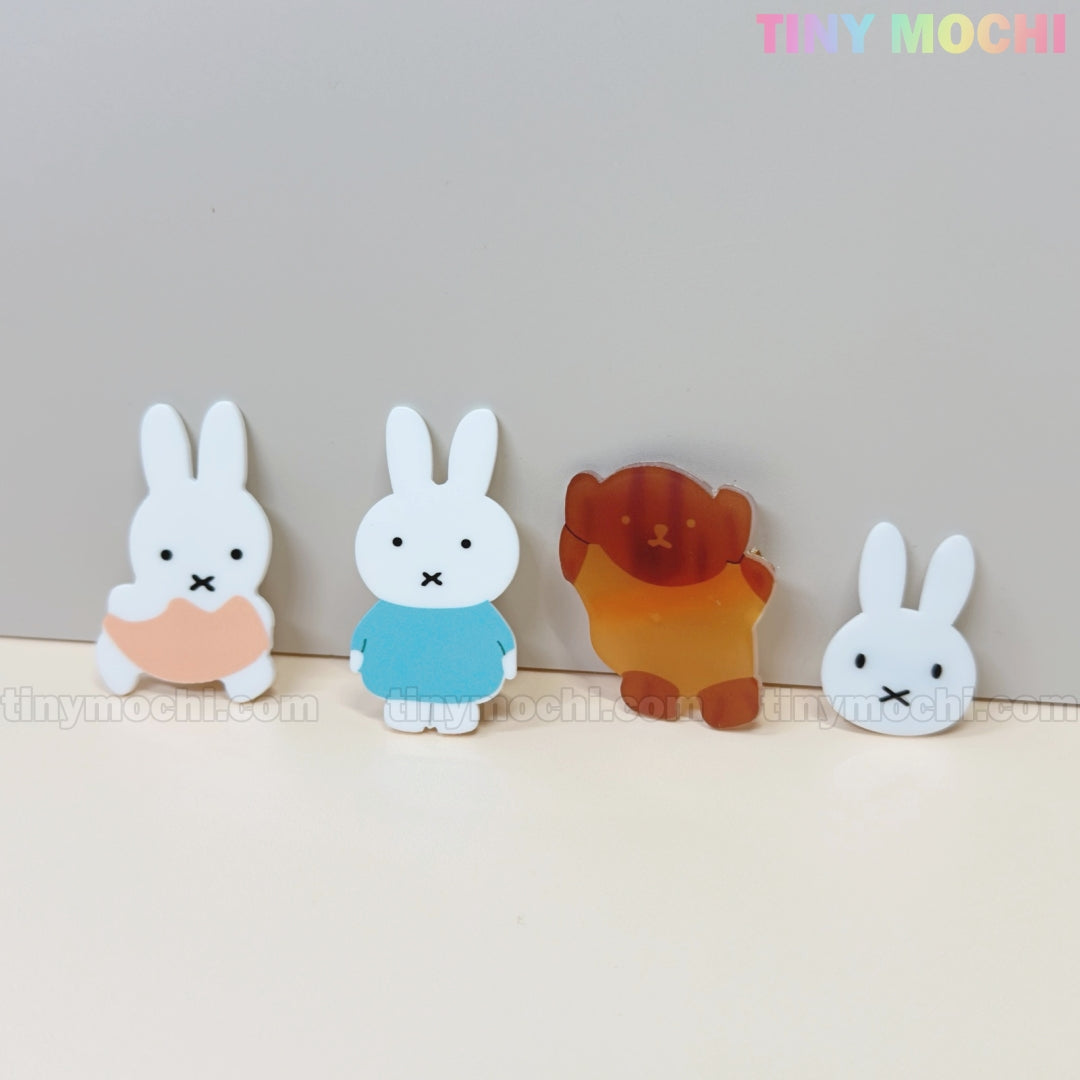 Four adorable Kawaii Bunny & Bear Acrylic Hair Clips from Tiny Mochi are displayed on a light gray background, featuring two bunnies (peach and blue outfits), a brown bear, and a bunny face. Perfect cute animal accessories for girls and women.