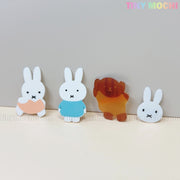Four adorable Kawaii Bunny & Bear Acrylic Hair Clips from Tiny Mochi are displayed on a light gray background, featuring two bunnies (peach and blue outfits), a brown bear, and a bunny face. Perfect cute animal accessories for girls and women.