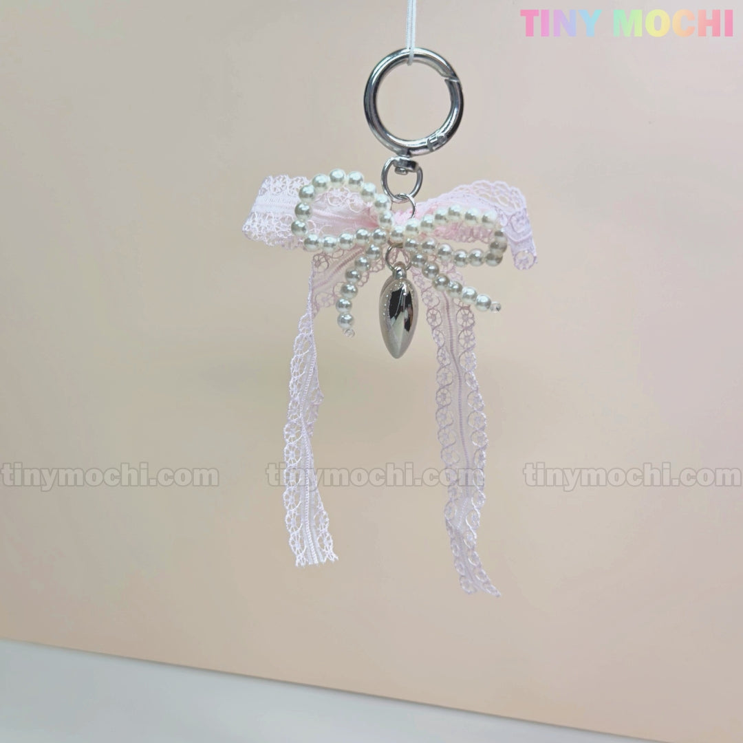 The Kawaii Lace Bow Keychain with Pearl Beads & Silver Heart Charm by Tiny Mochi is a cute bag charm, phone strap, or car mirror accessory, perfect for adding coquette style to your look.