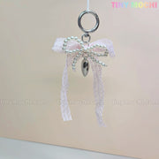 The Kawaii Lace Bow Keychain with Pearl Beads & Silver Heart Charm by Tiny Mochi is a cute bag charm, phone strap, or car mirror accessory, perfect for adding coquette style to your look.