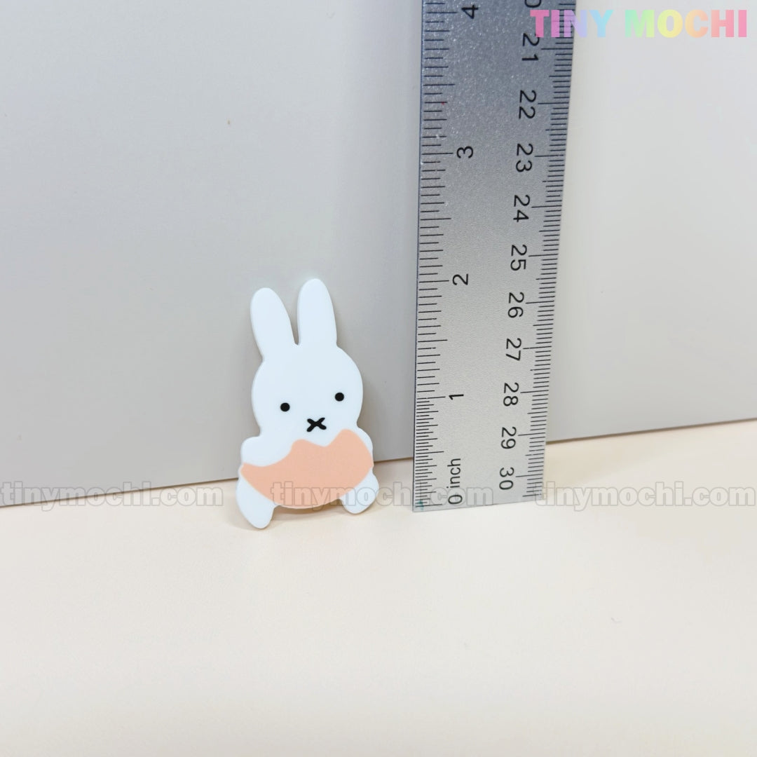 A small, white bunny figurine (about 2 tall) stands by a ruler for scale. The Tiny Mochi watermark is visible in the light background—cute next to Kawaii Bunny & Bear Acrylic Hair Clips by Tiny Mochi.