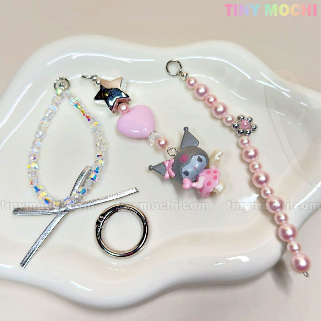 Displayed on a tray is the Tiny Mochi Kawaii Angel Charm Keychain Kit, featuring DIY pearls, ribbons, stars, and cute accessories for creating your own phone or bag keyring.