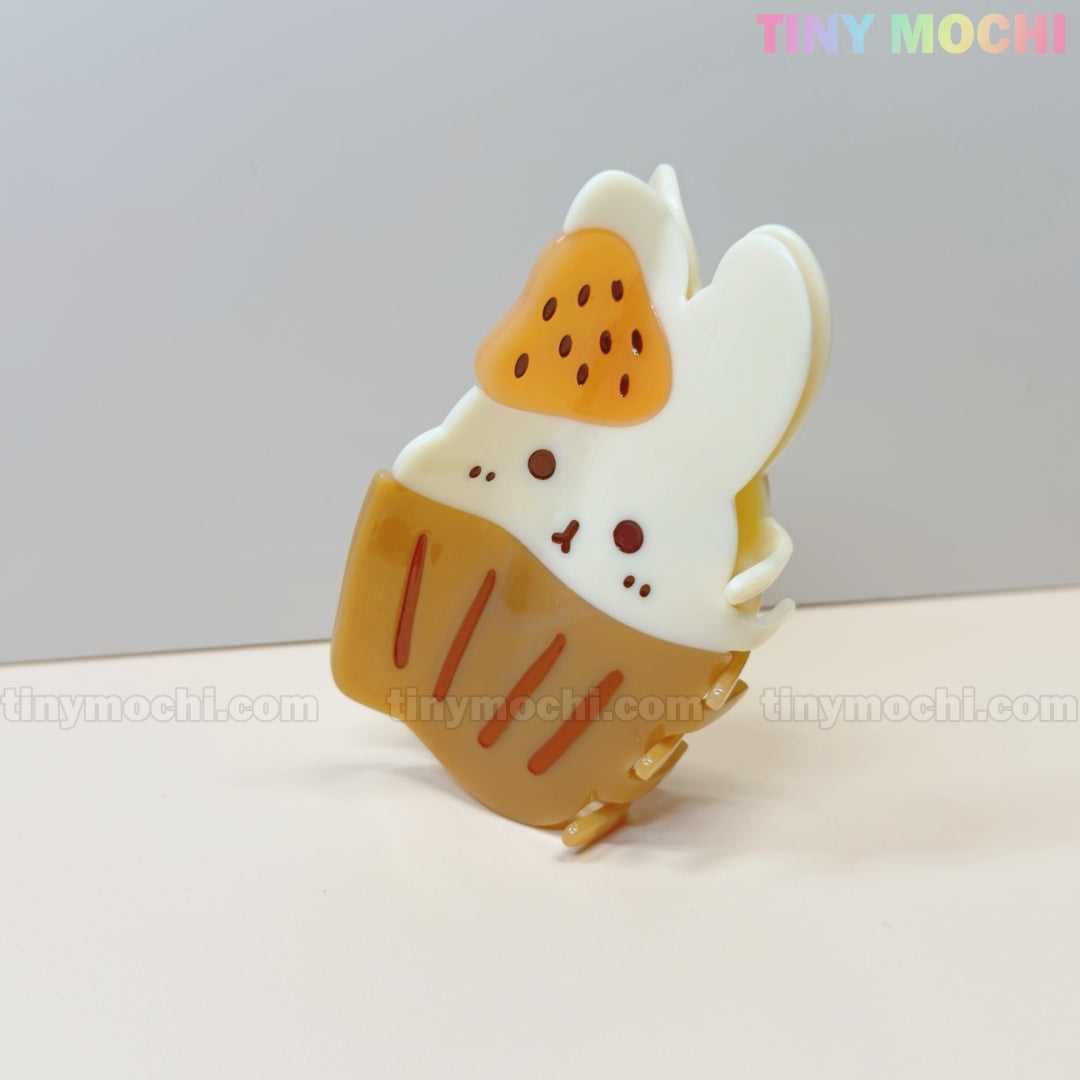 The Tiny Mochi Kawaii Cupcake Bunny Hair Claw Clip is a cute acrylic accessory for women and girls, featuring a strawberry dessert-style bunny design thats perfect for adding whimsical charm to your hairstyle.