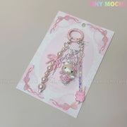 The Kawaii Pink Pearl Keychain by Tiny Mochi features pink and pearl beads, a pink bow, and a sweet kitty angel charm—a pastel coquette accessory for your bag or phone that adds a cute touch to your kawaii style.