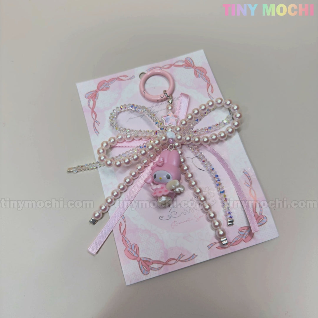 The Kawaii Bow Charm Keychain by Tiny Mochi features a pastel pink ribbon bow with a pearl, My Melody charm, and ring at the top—perfect as a Coquette Angel bag charm or DIY phone accessory.