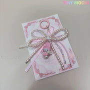 The Kawaii Bow Charm Keychain by Tiny Mochi features a pastel pink ribbon bow with a pearl, My Melody charm, and ring at the top—perfect as a Coquette Angel bag charm or DIY phone accessory.