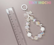 The Adorable Faux Pearl Bag Charm Keyring by Tiny Mochi is shown beside a transparent ruler, with TINY MOCHI in pastel on the top right—a cute accessory ideal as a backpack companion or beaded phone charm.