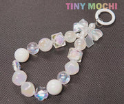 The Adorable Faux Pearl Bag Charm Keyring by Tiny Mochi features iridescent and pearl-like beads, clear cubes, and a butterfly charm—an ideal Bohemian accessory for your backpack or as a cute phone charm.