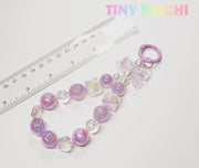 The Tiny Mochi Adorable Faux Pearl Bag Charm Keyring is shown next to a ruler and under pastel branding, featuring faux pearls, a bow, and a round clasp—perfect as a cute backpack companion.