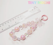 The Adorable Faux Pearl Bag Charm Keyring by Tiny Mochi, featuring pink, pearl, and clear beads, is shown beside a transparent 15 cm ruler. The pastel words Tiny Mochi appear in the top right corner.