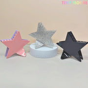 Three Star Hair Claw Clips by Tiny Mochi—Large Glitter Star Clips in pink, silver, and black—are displayed on a light background with pastel TINY MOCHI text at the top right. A perfect Y2K acetate hair accessory for thick hair.
