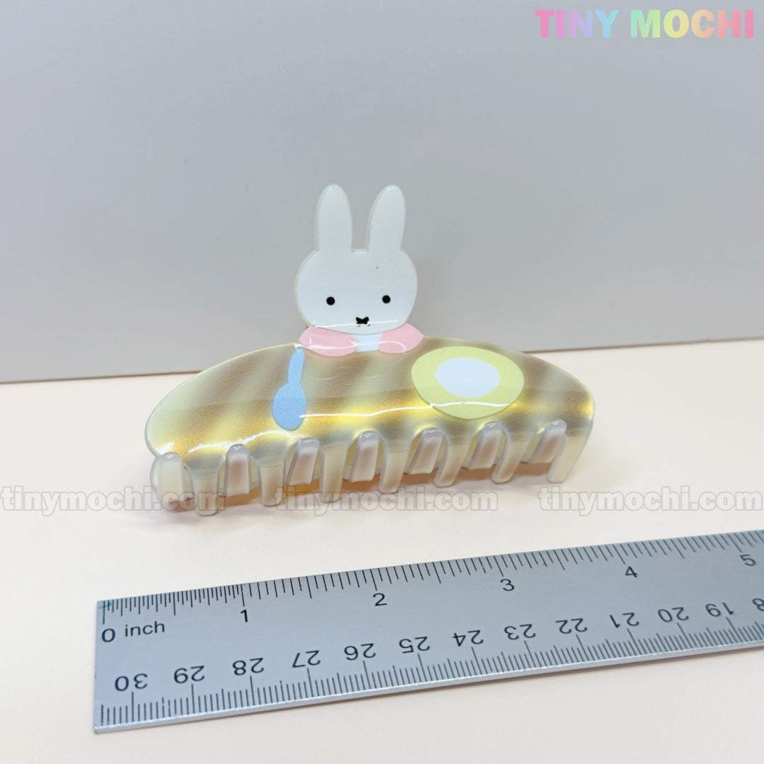 The Tiny Mochi Kawaii Bunny Breakfast Hair Claw Clip, a pastel acrylic accessory shaped like a bunny with pancake and egg, is shown beside a ruler for scale. TINY MOCHI appears in the top right corner of the iridescent clip.