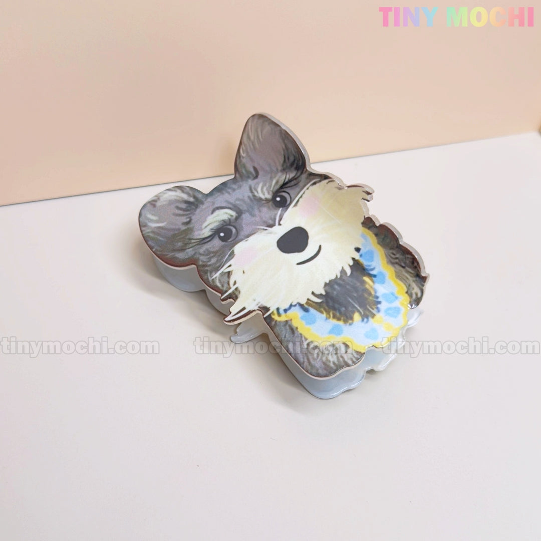 The Tiny Mochi Kawaii Dog & Cat Hair Claw Clips come in a cute dog-shaped tin with an illustrated gray and white pup wearing a blue and yellow collar—perfect for storing your adorable pet-themed hair accessories.