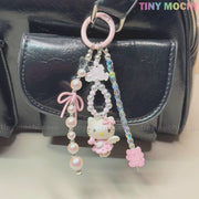 The Kawaii Pink Pearl Keychain from Tiny Mochi features pink and iridescent beads, sweet charms, and adds a cute coquette touch to any black leather bag or phone.