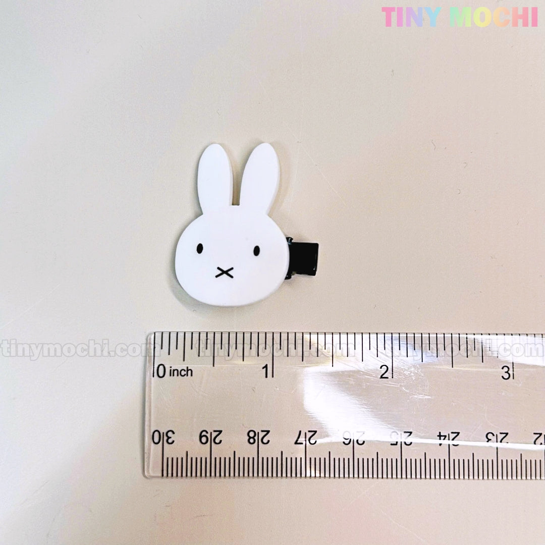 A white bunny-shaped clip from Tiny Mochi’s Kawaii Bunny and Bear Hair Clips for Girls lies by a transparent ruler, showing it’s about 4 cm wide. “TINY MOCHI” is printed in pastel colors in the top right corner.