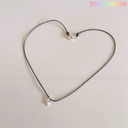 A Sterling Silver Starfish Necklace by Tiny Mochi, featuring a handmade 925 silver charm on a black beaded pearl choker, is shaped into a heart on a light background. The words TINYMICHI.COM and TINY MOCHI are faintly visible behind.