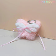 The Tiny Mochi Plush Butterfly Bow Keychain is a pink fuzzy bag charm with white wings and a silver keyring—perfect as a soft girl or coquette cute gift and accessory, shown on a light pink background.