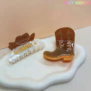 Tiny Mochi’s Western Cowboy Hair Claw Clips—cute cowgirl barrettes with boot and hat designs—add a fun Western touch to your glossy white tray display.