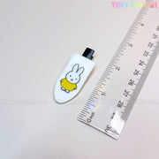 A Kawaii Bunny Hair Clip from Tiny Mochi—featuring a cute bunny in a yellow shirt—is displayed by a ruler on a white surface. This colorful cartoon resin alligator clip makes an adorable barrette gift for girls.