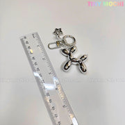 A Balloon Dog Keychain Silver Chrome Bag Charm with Star Accent by Tiny Mochi lies next to a clear ruler on a white surface, with the “tiny mochi” watermark featured multiple times on this cute metallic purse accessory gift.