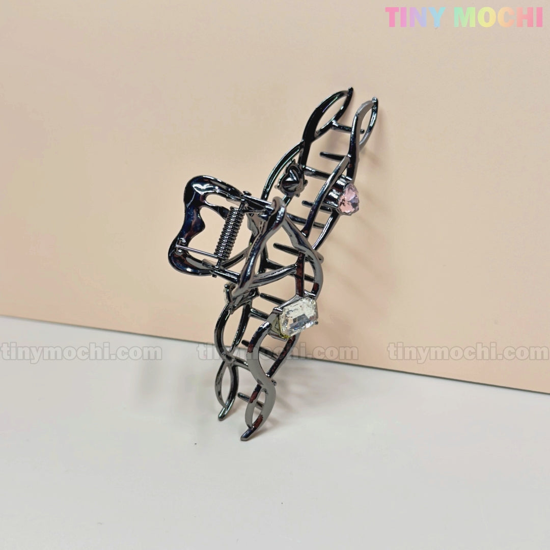 The Dark Silver Crystal Heart Hair Claw by Tiny Mochi is an elegant cat-shaped metal hair clip with curled tail, pink and clear gemstones, and sparkling crystal hearts. Displayed on a light beige background with TINYMochi.com watermarks.