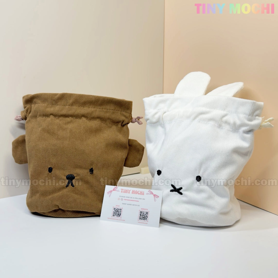 The Kawaii Bunny & Bear Drawstring Pouch – Corduroy Coin Makeup Bag by My Store features a brown bear and a white bunny pouch, each with cute faces and ears, displayed side by side in front of a business card on a light background.