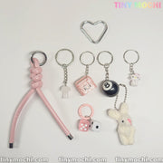 Tiny Mochis Cute Bunny and Charm Keychain is an aesthetic bag charm featuring kawaii charms like a knotted pink strap, heart ring, cat, bunny, dice, 8 ball, milk bottle & mini backpack—perfect coquette accessory for purses & backpacks.