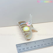 The Tiny Mochi Kawaii Bunny Breakfast Hair Claw Clip, featuring a cute pancake and egg design, sits beside a metallic ruler with cm and inch marks. The pastel background displays Tiny Mochi in the top right corner.