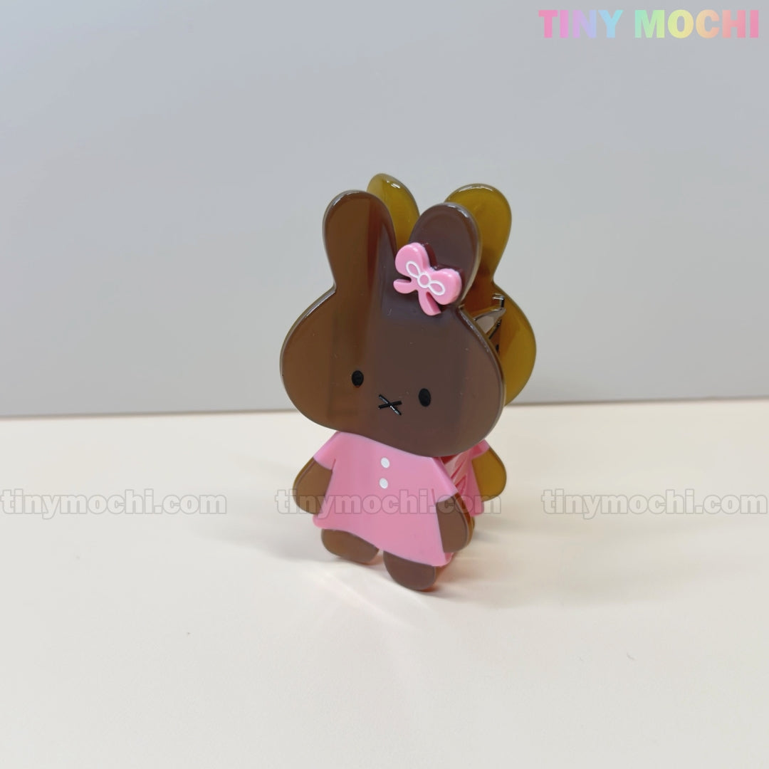 The Kawaii Bunny Hair Claw Clip by Tiny Mochi features a cute pastel acrylic bunny in a dress with a bow, standing upright on a light surface. The brand name appears in pastel colors in the top right corner.