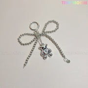 The Silver Teddy Bear Bow Keychain by Tiny Mochi is a cute bag charm accessory for women, teens, and Kawaii lovers, featuring a silver beaded bow and shiny teddy bear charm on a light background with pastel TINY MOCHI text.