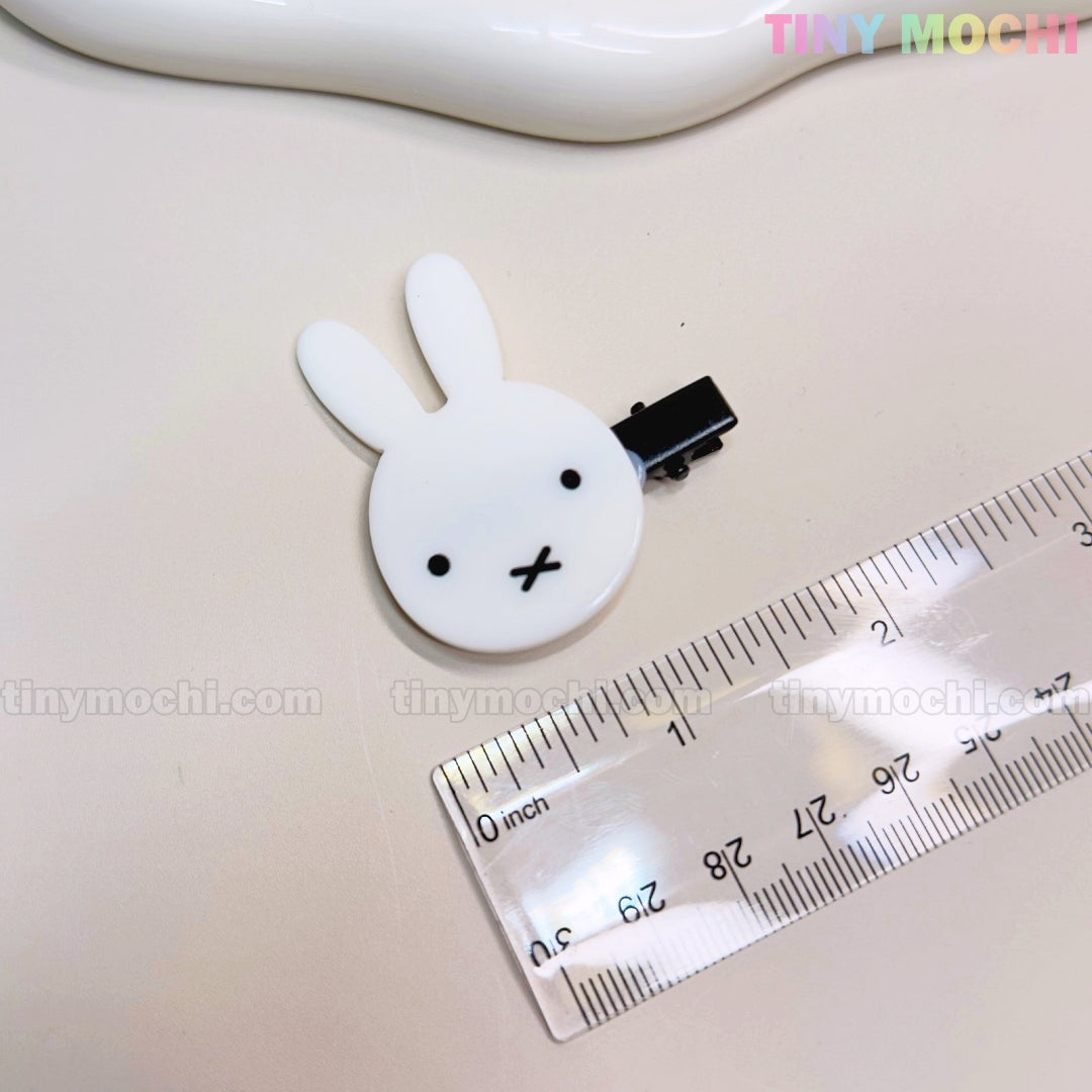 A white bunny hair clip from Tiny Mochis Kawaii Bunny and Bear Hair Clips for Girls set sits by a clear ruler on a light surface. This cute 2-inch accessory is perfect for fans of adorable, aesthetic kids’ hair accessories.