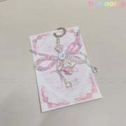 The Cotton Candy Wings Charm Keychain by Tiny Mochi features kawaii pastel beads, a cute Cinnamoroll charm, pink and blue bows, and star accents in fairycore style, displayed on a pink card with the brand name in colorful letters.