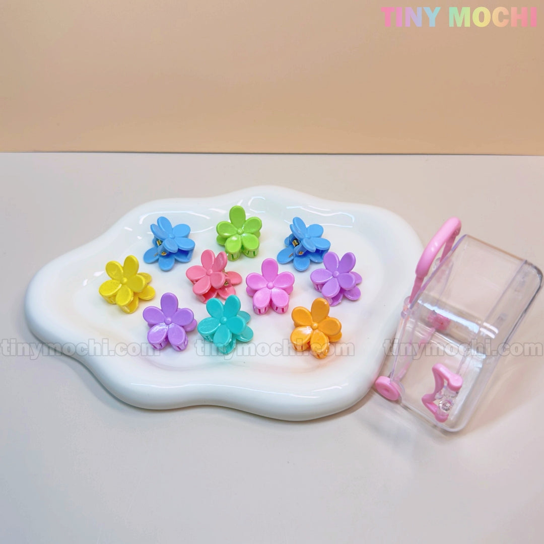 The Tiny Mochi Kids Hair Clips Set includes 10 colorful kawaii hair claws in butterfly, flower, heart, and more designs, all organized in a mini travel case with a pink handle and clasp.