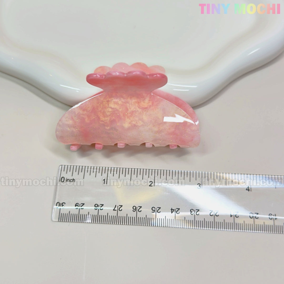 The Tiny Mochi Pastel Hair Claw Clip, a color-changing UV-reactive acetate accessory for women & girls, is shown on a white surface beside a clear cm ruler, with scalloped edging and the pastel Tiny Mochi logo in the top right.