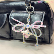 Add a touch of fairycore style to your bag with Tiny Mochis Cotton Candy Wings Charm Keychain—a kawaii beaded bow accessory in pastel pink and blue, complete with a cute charm, perfect for any black handbag.