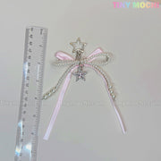 The Pink Star Bow Charm Keychain by Tiny Mochi features ribbons, pearl beads, and a silver star pendant, displayed beside a clear ruler for scale. Tiny Mochi appears in pastel colors—a perfect kawaii Y2K phone or bag accessory.