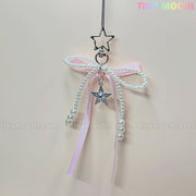 The Pink Star Bow Charm Keychain by Tiny Mochi features a star-shaped clip, pink ribbon bow, faux pearl strands, and a silver star pendant—ideal as a kawaii Y2K phone charm or coquette bag accessory gift.