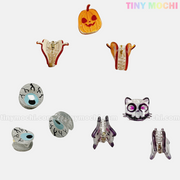 Kawaii Halloween Mini Claw Clips from Tiny Mochi Gift Shop Houston: cute pumpkin, fang, eyeball, skull, and sleepy eye shapes—spooky hair accessories for a kawaii touch. Displayed on white with TINY MOCHI logo.