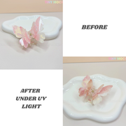 The Tiny Mochi NEW UV Color-Changing Butterfly Hair Claw Clip—Double Layer Acetate Pastel Hair Accessory appears pale pink on a white dish (BEFORE) and glows bright pink and orange under UV light (AFTER), as labeled in the photos.