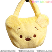The Adorable Kawaii Handbag by Tiny Mochi is a soft plush bear-face purse featuring round ears, embroidered eyes, and a brown nose—a cute and practical must-have accessory for fashionable kids. Displayed on a white background with colorful branding.