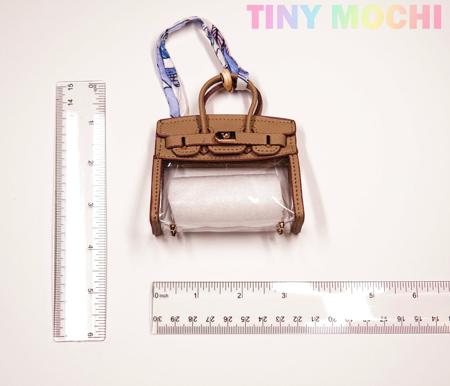 A transparent, tote-shaped mini bag key holder by Tiny Mochi is shown between two rulers for scale (about 3 tall and 4 wide). This durable, chic TPU key pouch is a stylish organizer for women, with TINY MOCHI branding in pastel at the top right.