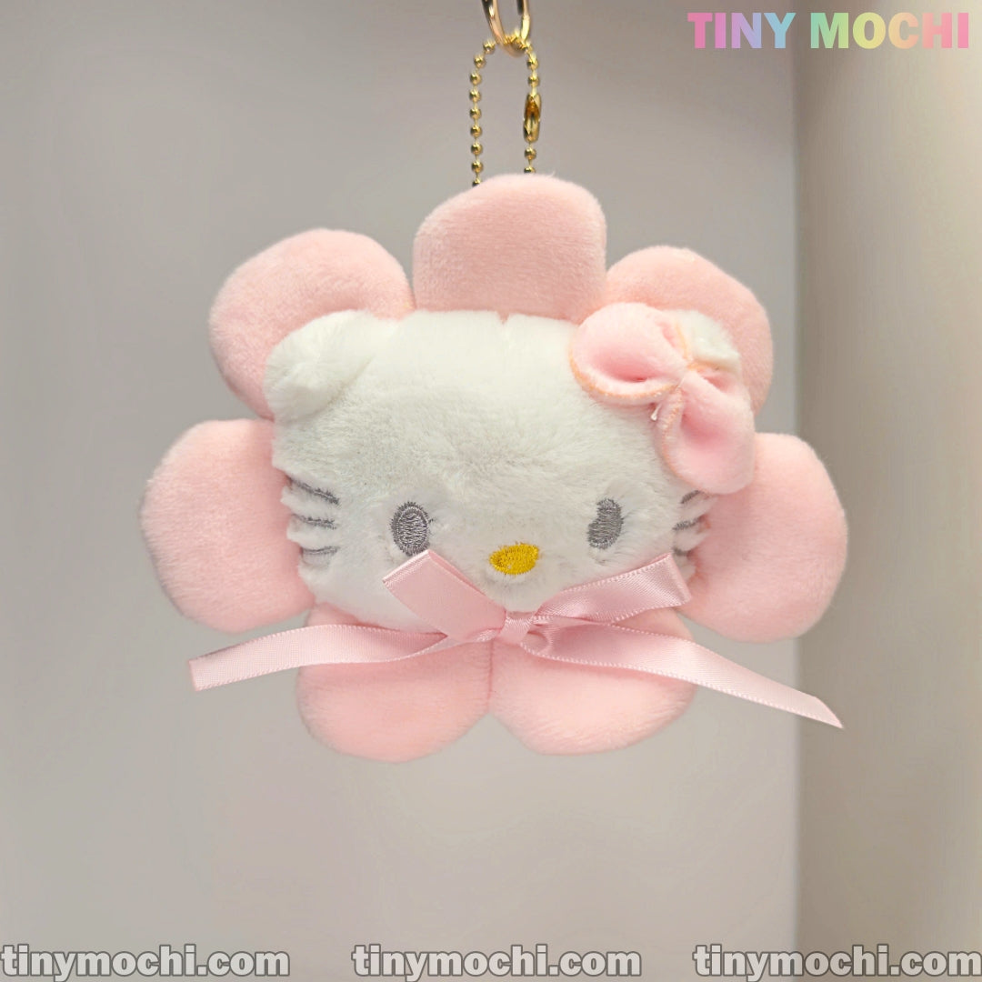 The Tiny Mochi Cute White Cat Kitty and Pinky Sunflower Plush Keychain is a soft, stuffed bag charm featuring a white cat face framed with pink petals, pink bow, yellow nose, gray eyes, ribbon front, and TINY MOCHI branding.
