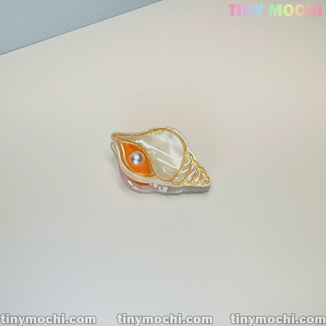 A mini ocean-themed animal acetate hair claw from Tiny Mochi’s Cute Sea Creature Hair Clips collection sits on a light surface. The image includes branding, highlighting this cute hair accessory for women and girls.