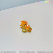 A mini orange seahorse-shaped acetate hair clip from Tiny Mochis Cute Sea Creature Hair Clips collection is displayed on a white surface, with tinymochi.com and the colorful TINY MOCHI logo visible in the image corners.