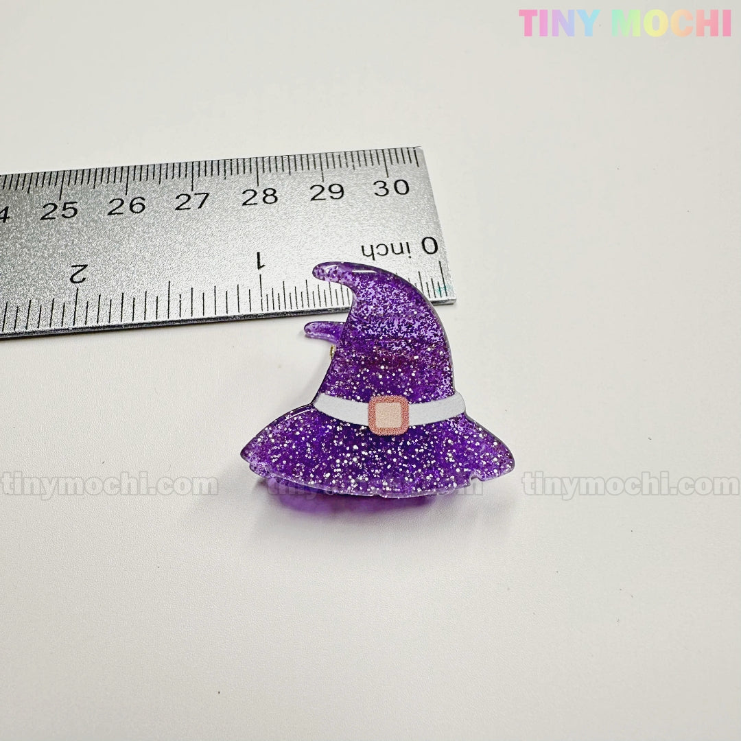 A glittery purple witch hat charm, about 1.5" tall, is shown next to a ruler. From Tiny Mochi Gift Shop Houston's Kawaii Halloween Hair Claw Clips – Set of 8 Spooky-Cute Designs. Perfect for hair clips, keychains, or bag charms.