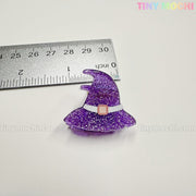 A glittery purple witch hat charm, about 1.5" tall, is shown next to a ruler. From Tiny Mochi Gift Shop Houston's Kawaii Halloween Hair Claw Clips – Set of 8 Spooky-Cute Designs. Perfect for hair clips, keychains, or bag charms.