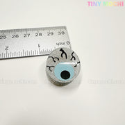 A round, glittery pin shaped like a blue eyeball with black veins is shown next to a ruler (about 1 inch wide). Perfect for pairing with Kawaii Halloween Mini Claw Clips by Tiny Mochi Gift Shop Houston. White background, TINYMochi in corners.