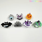 Add playful flair to your look with seven Halloween-themed pins and pair them with Kawaii Halloween Mini Claw Clips from Tiny Mochi Gift Shop Houston for extra spooky cute style!.